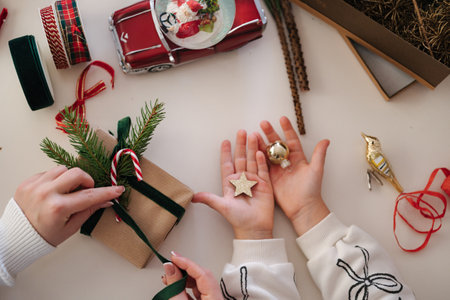 Top view of mom and daughter packing presents for Christmas Eve. Happy family spend time tougher on winter holidaysの写真素材