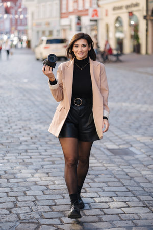 Beautiful woman photographer walking in the city with mirrorless camera. Life style conceptの写真素材