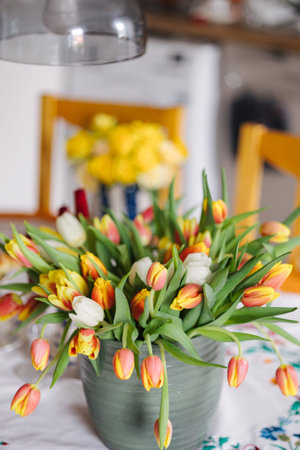 Different colored flowers in vase on the table. Colorful and beautiful fresh tulips