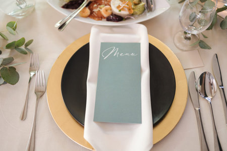 Top view of beautiful and served table in restaurant. Golden plate and lot of cutleryの写真素材