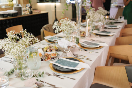 Stylish wedding table in restaurant. Table decorated with flowers and candles. Beautiful and bright...