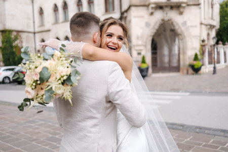 Newlyweds walking in the city centre in Europe. Beautiful wedding couple surrounded of old architectureの写真素材
