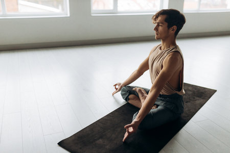 Side view of handsome calm focused guy sitting on floor meditating relaxation. Yoga man conceptの写真素材