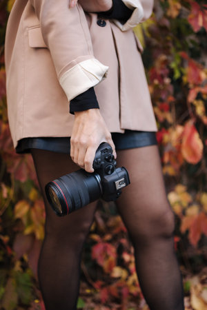 Middle selection of female hold professional camera in hand. Close up photographers equipment