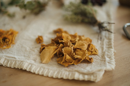 Macro photo of dried yellow rose leaves on a linen tableclothの写真素材