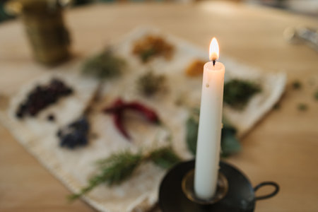 Candle on an old metal stand. Preparing nutritional supplements to improve human immunity and health. Dried herbs and seasonings.の写真素材