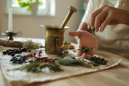 Close-up of man adds dried herbs to a mortar and pestle. Homemade healthy and nutrition supplementsの写真素材
