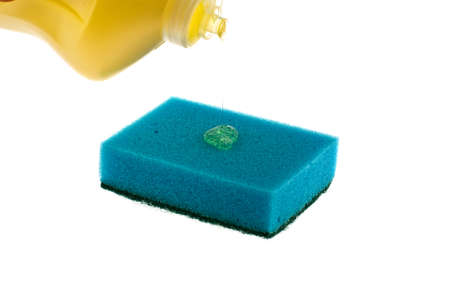 The washing-up liquid follows from a bottle on a sponge on a white backgroundの写真素材