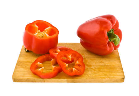 On a chopping board fruits of red pepper - one whole lie, and the second is cutの写真素材