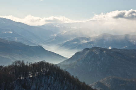 In the winter morning of a smoke rises from a river valley uphillの写真素材