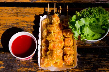 steamed dumplings with dip sauce and fresh vegetable.の写真素材