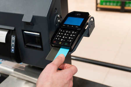 Close-up of credit card near payment terminal at self checkout machine. Cashless transaction and...