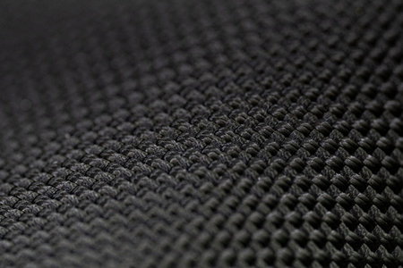Detailed view of interlaced carbon fiber strands forming a glossy grid pattern, showcasing strength...