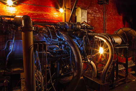 Aircraft engine on the background of a red wall in the semi-darkness.