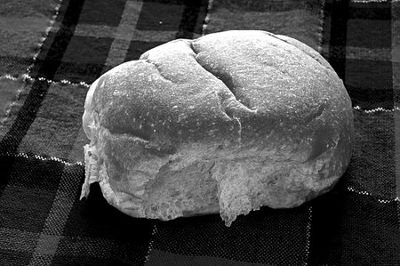 Bread roll on tartan tablecloth in black and white