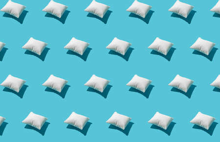 Pattern made of white pillow on serenity pastel blue background. Sleeping concept. Isometric flat lay.の写真素材