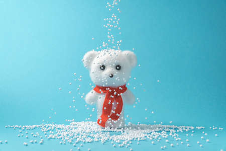 Creative composition made of white teddy bear with red scarf and snow. Minimal winter concept.の写真素材