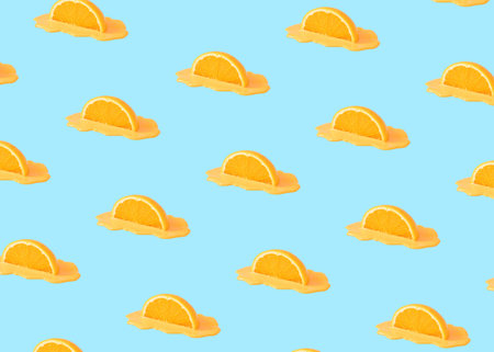 Creative summer pattern with halved orange fruit on bright background. Minimal fresh nature concept.