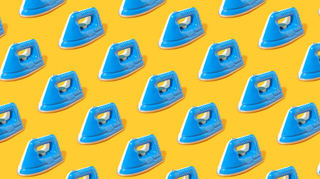 Trendy pattern with blue steam iron on bright orange table. Creative housekeeping background.