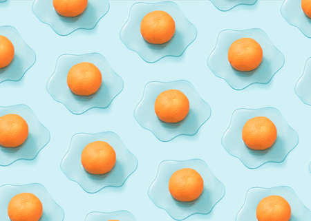 Creative sunny side up egg pattern made of fresh tangerine and slime on pastel blue background.  Minimal vegan breakfast concept.の写真素材