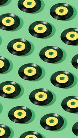 Trendy pattern made of yellow label  vinyl record on mint green. Minimal retro music vertical background.の写真素材