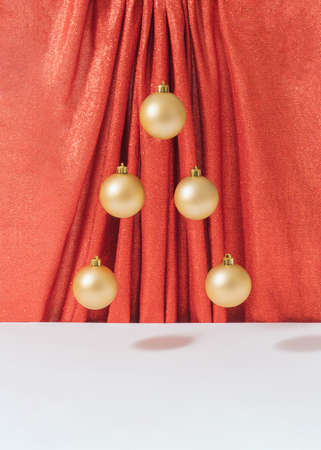 Creative retro Christmas composition with gold bauble decoration against shiny red curtain. Surreal vintage New year concept.の写真素材