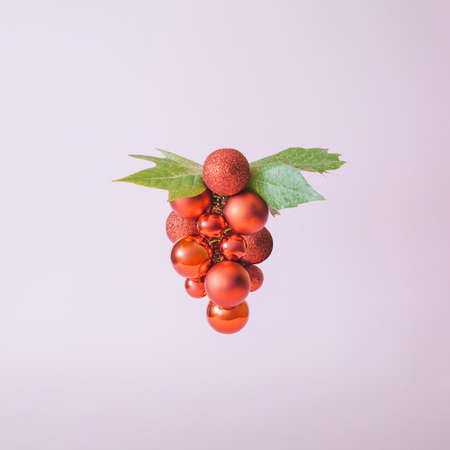 Creative composition with red Christmas ornament falling out of ice cream cone on bright yellow background. Minimal holiday sweets concept.の写真素材
