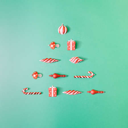 Creative composition with red Christmas ornament falling out of ice cream cone on bright yellow background. Minimal holiday sweets concept.の写真素材