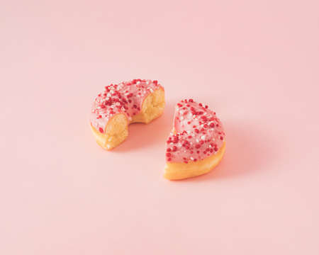 Minimal composition with pink donut cutted in half against pastel pink background. Isometric view.の写真素材