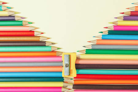 Creative arangement with colorful pencils and yellow sharpener on pastel background. School template with creative copy space.の写真素材