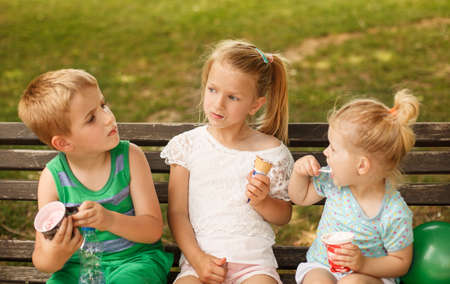 Kids enjoying outside and eating icecream.の写真素材