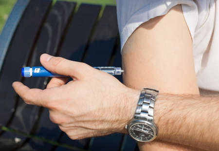 Young man is having insulin injection.の写真素材