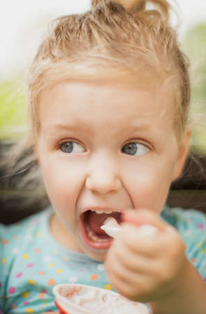 Young girl is eating icecream.の写真素材
