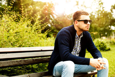 Young man is sitting in the park.の写真素材