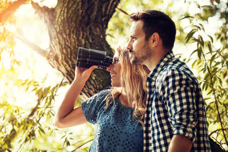 Friends enjoying camping and using binoculars.の写真素材