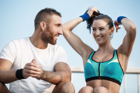 Happy couple relaxing after exercising outdoors.