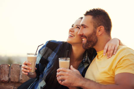 Young couple enjoying outside and drinking coffee.の写真素材