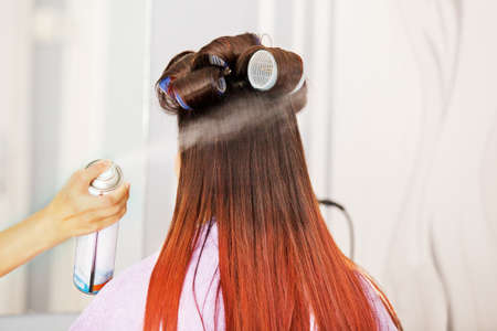 Red hair young woman at hairdresser.の写真素材
