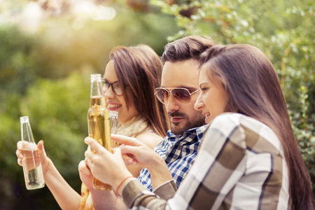 Group of young people having fun in the park and eating pizza.