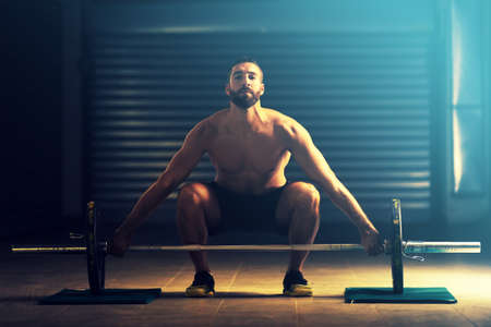 Young strong man pulling up weight.の写真素材