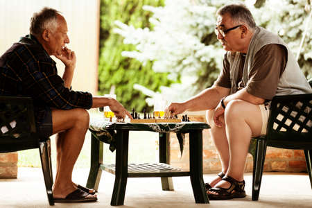 Two senior friends is  playing chess early in the morning.の写真素材