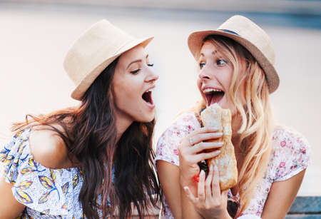 Beautiful girls eating sandwiches.の写真素材