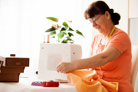 Senior woman sewing at home.