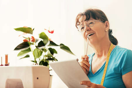 Senior woman sewing at home.の写真素材