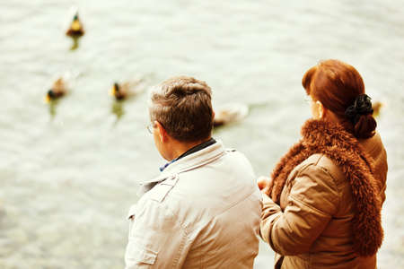 Happy senior couple feeding ducks on Thun's Lake Switzerland. の写真素材