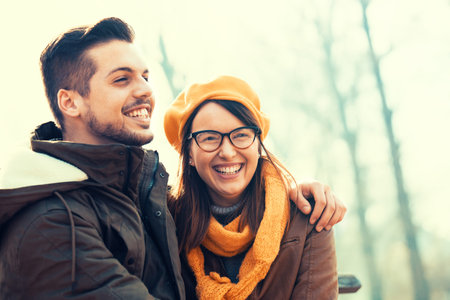 Young and attractive couple enjoying fall in the park.
