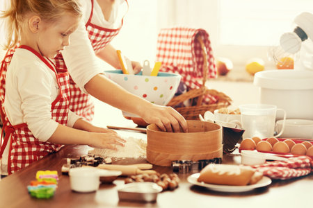 Mum and daughter baking cakes. 
