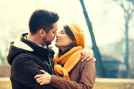 Young and attractive couple enjoying fall in the park.の写真素材