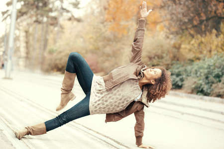Young woman demonstrating yoga pose on the street. の写真素材