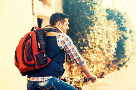 Young handsome man is riding bike in the city.の写真素材